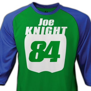 May include: Green and blue baseball jersey with white lettering. The jersey has the name "Joe Knight" and the number "84" on the front.