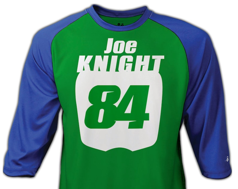 May include: Green and blue baseball jersey with white lettering. The jersey has the name "Joe Knight" and the number "84" on the front.