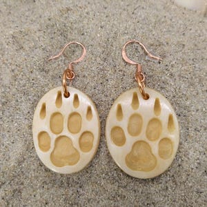 Puede incluir: Un juego de tres tazas de cerámica con un esmalte moteado de color crema. Cada taza presenta un diseño floral pintado a mano en tonos azules, verdes y amarillos. Las tazas tienen una forma simple y redondeada y un asa cómoda.