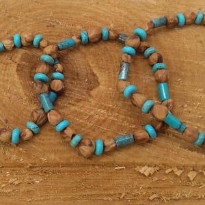 Puede incluir: Tres pulseras hechas con cuentas de madera marrón y cuentas de color azul turquesa.