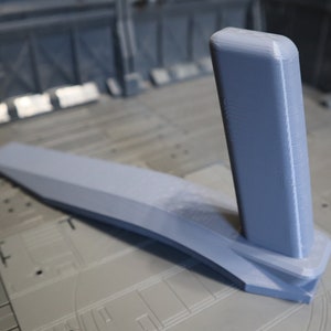 Puede incluir: Un modelo de tren de aterrizaje de nave espacial impreso en 3D de color gris. El tren de aterrizaje está hecho de plástico y tiene una superficie lisa. El tren de aterrizaje está diseñado para ser utilizado con un modelo de nave espacial.
