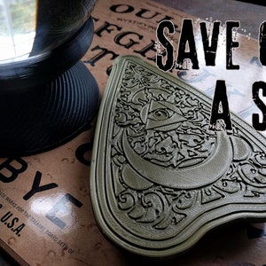 Puede incluir: Un posavasos triangular de plástico verde ornamental con un diseño de ojo que todo lo ve. El posavasos está sobre una superficie marrón con el texto "SAVE ON A SET" en letras negras.