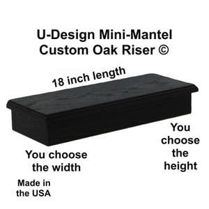 May include: A black oak wood riser with a rectangular shape and a flat top surface. The text U-Design Mini-Mantel Custom Oak Riser, 18 inch length, You choose the width, You choose the height, and Made in the USA is printed around the object.