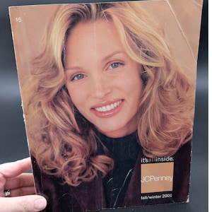 May include: A vintage JCPenney Fall/Winter 2001 catalog cover featuring a smiling woman with blonde hair and blue eyes. The catalog has a $5 price tag in the upper left corner.