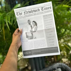Puede incluir: Una persona sostiene un anuncio de boda estilo peri&oacute;dico, titulado "The Newlywed Times". El titular dice "Latoya and Jamar are getting married". La foto en blanco y negro muestra a la pareja. El peri&oacute;dico incluye detalles de la boda.