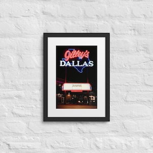Puede incluir: Una fotografía en blanco y negro de un letrero de neón que dice "Gilley's Dallas" en letras rojas y azules. El letrero está montado en un edificio con un marquesina que dice "The Outlaw with Rory Gales".