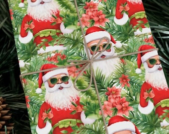May include: A wrapped gift with a festive Santa Claus pattern. The wrapping paper features Santa in sunglasses, red suits, and white beards, surrounded by green foliage and red flowers. The gift is tied with twine and set on a bed of pine needles and pine cones.