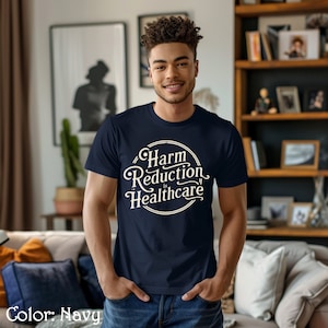 May include: A navy blue t-shirt with a white circle graphic that says "Harm Reduction is Healthcare".