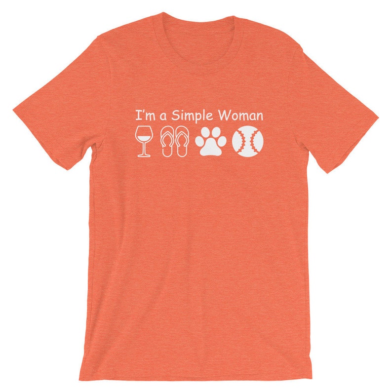 May include: Orange short-sleeved t-shirt with the text "I'm a Simple Woman" and white icons of a wine glass, flip-flops, a paw print, and a baseball.