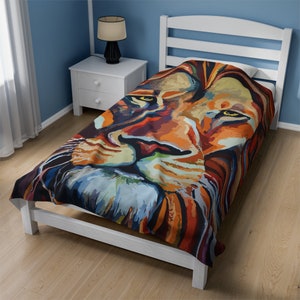 Könnte beinhalten: Ein farbenfrohes Gemälde eines Löwenkopfes auf einer weißen Bettdecke in Zwillingsgröße. Das Löwenkopf ist in einem lebendigen Stil mit Orange-, Gelb-, Blau- und Rottönen gemalt.