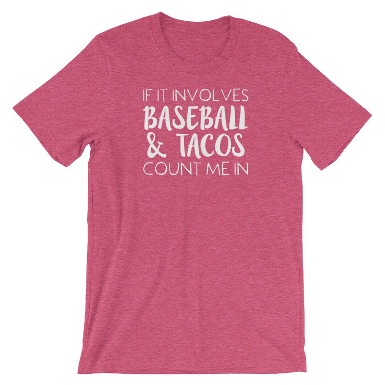 May include: Pink t-shirt with white text that reads "If it involves baseball & tacos count me in."