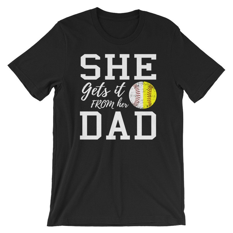 May include: Black t-shirt with white text that reads "SHE gets it FROM her DAD" and a yellow softball graphic.