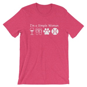 May include: Pink short-sleeved t-shirt with the text "I'm a Simple Woman" and white icons of a wine glass, flip flops, a paw print, and a baseball.