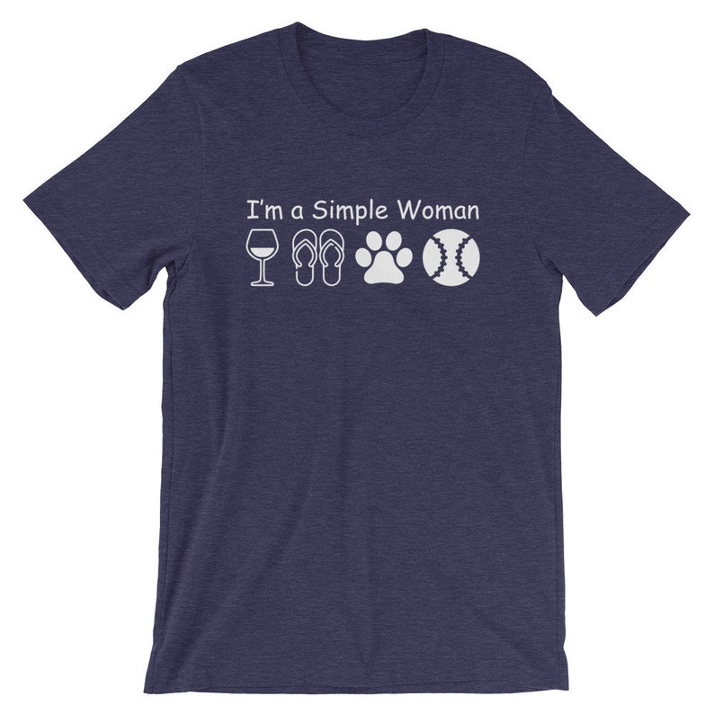 May include: A navy blue t-shirt with the text "I'm a Simple Woman" and white icons of a wine glass, flip flops, a paw print, and a baseball.