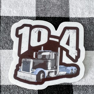 Pode incluir: Um adesivo branco com um caminhão de plataforma marrom e preto desgastado e o texto "10-4" em branco.