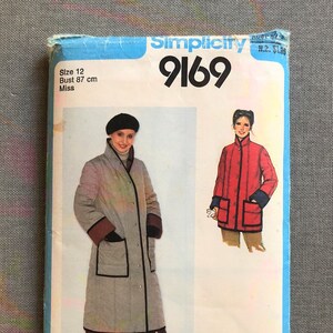 May include: Simplicity sewing pattern number 9169 for a long quilted coat with a black trim. The pattern is for a size 12, bust 87 cm, and is for misses.