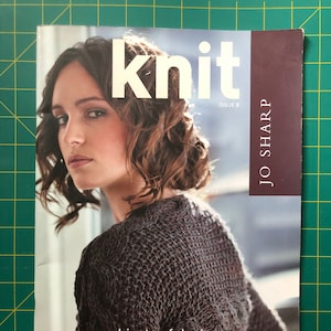 May include: A magazine cover featuring a woman wearing a brown knitted sweater. The magazine is titled "knit" and the subtitle is "objects of desire 13 hand knitting projects".