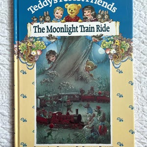 May include: A children's book titled "Teddy's Forest Friends: The Moonlight Train Ride." The cover shows illustrations of teddy bears, children, and rabbits. A red train is depicted in a forest scene, with the author's name, Shirley Barber, at the bottom.