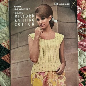 May include: A vintage crochet pattern leaflet for a shell pattern top in yellow cotton. The leaflet is titled "Strutt's Milford Knitting Cotton" and features a woman wearing the crocheted top.