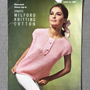 May include: A vintage magazine cover showing a woman in a pink open-work leisure top. The top has a buttoned placket and short sleeves. The text reads "STRUTT'S MILFORD KNITTING COTTON" and "Open-work leisure top in". The background is a green gradient.
