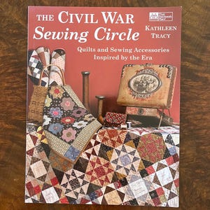 May include: The Civil War Sewing Circle book cover showing quilts and sewing accessories. The cover features a quilt with geometric patterns and the text "The Civil War Sewing Circle" and "Kathleen Tracy".