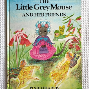 May include: A hardback book titled The Little Grey Mouse AND HER FRIENDS by Pixie O'Harris. The cover features a central illustration of a mouse wearing a bonnet and pink dress, surrounded by three winged fairies, red flowers, and mushrooms.