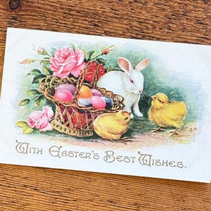 Antike Osterhasen und Küken Postkarte mit einem hübschen Korb mit farbigen Eiern und schönen rosa Rosen, mit besten Wünschen zur Osterzeit