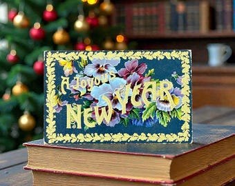 アンティークの新年のお祝いポストカード。金箔押しで紫のパンジーがあしらわれています。飾ったり、コレクターへの贈り物に最適です。