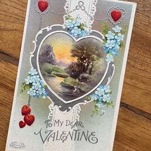 Antike Valentinstag Postkarte mit roten Herzen und blauen Vergissmeinnicht Blumen auf silbernem Hintergrund, Blick auf den See eines Fischers, gebrauchte Vintage