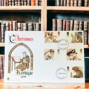 以下が含まれることがあります： クリスマスをテーマにした白い封筒。封筒には、本に書き込んでいる修道士の絵と「クリスマス・ヘリテージ・イヤー」の文字が描かれている。封筒には、宗教的なシーンを描いた5つの切手と「First Day of Issue 20 Nov 1984 Cleveland」の文字も書かれている。