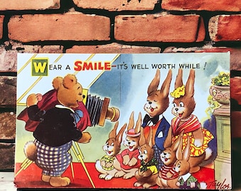 Wear A Smile Vintage Postcard by Arnold Taylor for Bamforth and Co, cute bunnies and a Teddy Bear on an unused Merry Message series card