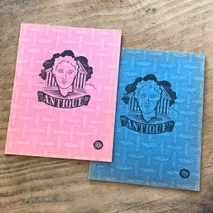 May include: Two vintage paperbacks with a blue and pink cover. Both covers feature a black and white illustration of a person's head with the word "Antique" in a banner below. The word "SEPA" is printed in the bottom right corner of each cover.