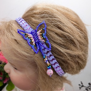 May include: Purple and blue beaded butterfly headband with a pink and white beaded charm hanging from the bottom.