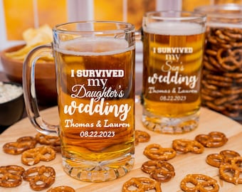 May include: Two clear glass beer mugs with handles. The mugs are filled with a golden-colored liquid. The mugs are decorated with white text that reads "I survived my daughter's wedding" and "I survived my son's wedding". The text also includes the names "Thomas & Lauren" and the date "08.22.2023".