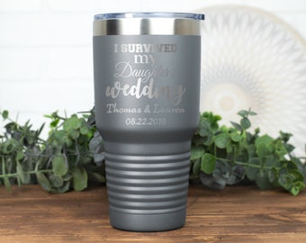 May include: Gray stainless steel tumbler with the text "I survived my daughter's wedding" and the names "Thomas & Lauren" and the date "08.22.2018".