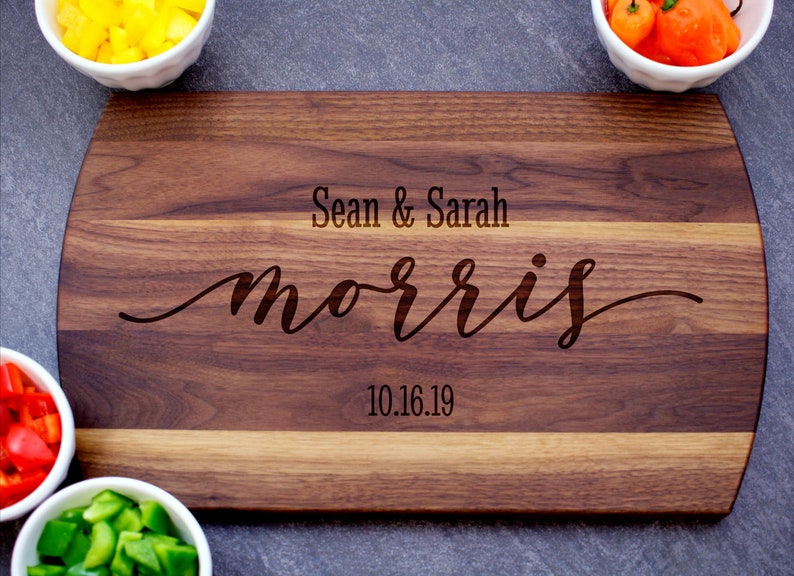 May include: A personalized walnut cutting board with the text "Sean & Sarah Morris 10.16.19" engraved on it.