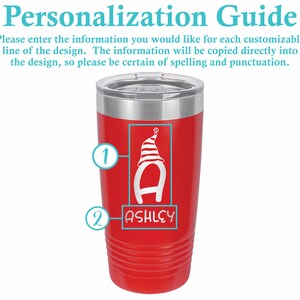 May include: Red stainless steel tumbler with a white design of a letter A wearing a striped hat and the name "ASHLEY" below it.