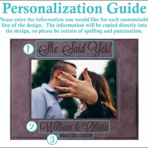 May include: A personalized photo frame with a brown leatherette finish. The frame has a cutout for a photo and three lines of text. The top line says "She Said Yes!" The second line says "William & Olivia" and the third line says "May 21, 2019".
