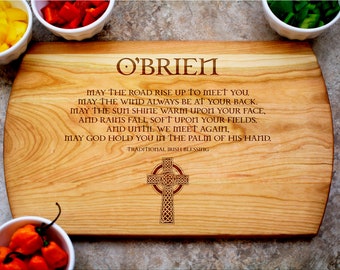 May include: A wooden cutting board with a Celtic cross design and the text "O'BRIEN" and a traditional Irish blessing. The board is made of light wood with a natural finish.