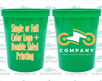 Pode incluir: Dois copos de plástico verde com um logotipo de uma única cor ou completo e impressão em ambos os lados. Um copo tem um logotipo de uma motocicleta com um plugue elétrico. O texto no copo diz "Single or Full Color Logo + Double Sided Printing" e "COMPANY YOUR TAGLINE GOES HERE".