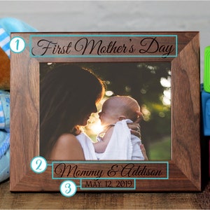Pu&ograve; includere: Una cornice per foto in legno marrone con una foto di una madre e un bambino. La cornice &egrave; incisa con il testo "First Mother's Day", "Mommy & Addison" e "May 12, 2019".