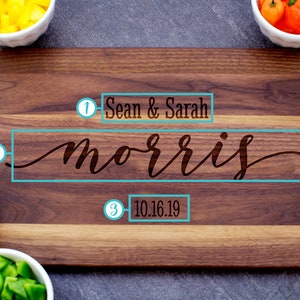 May include: A wooden cutting board with a personalized inscription. The inscription reads "Sean & Sarah Morris 10.16.19".