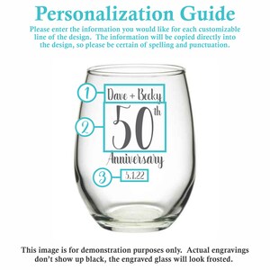 May include: A clear glass wine glass with a personalized design. The design includes the text "Dave + Becky 50th Anniversary 5.1.22" in a gray square with a blue border.