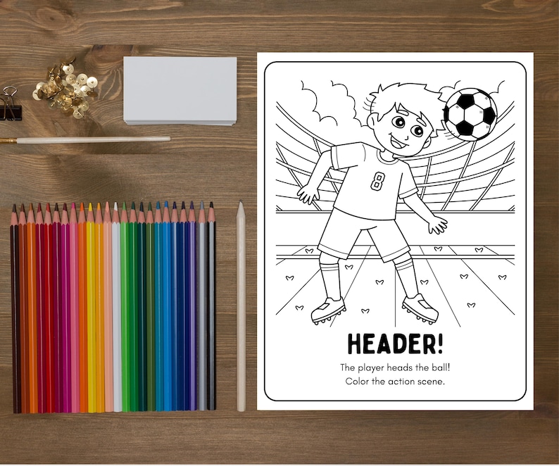 May include: A coloring book page with a soccer theme, featuring a player heading a soccer ball. The text "HEADER!" is at the bottom, along with instructions to color the scene. A set of colored pencils and a white pencil are next to the coloring book.