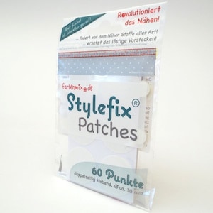 Könnte beinhalten: Eine Packung mit 60 weißen, selbstklebenden Stoff-Patches, genannt Stylefix Patches, zum Nähen. Die Packung ist grün und weiß mit dem Text "Stylefix Patches" und "60 Punkte" (60 Punkte).
