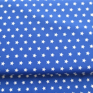 Könnte beinhalten: Blauer Stoff mit einem weißen Sternenmuster. Der Stoff ist in der Mitte gefaltet.