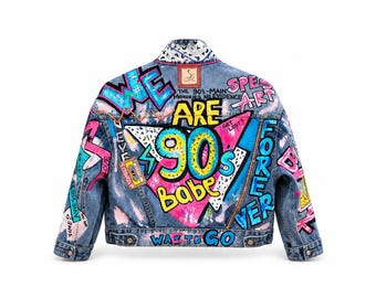 May include: A blue denim jacket featuring vibrant, multi-colored graffiti-style artwork and text including "WE ARE 90s Babe", "SPE ART", "FOREVER", "WAY TO GO", and "THE 90s-MAIN MEMORIES NO EVIDENCE". The design includes cassette tapes and geometric shapes.
