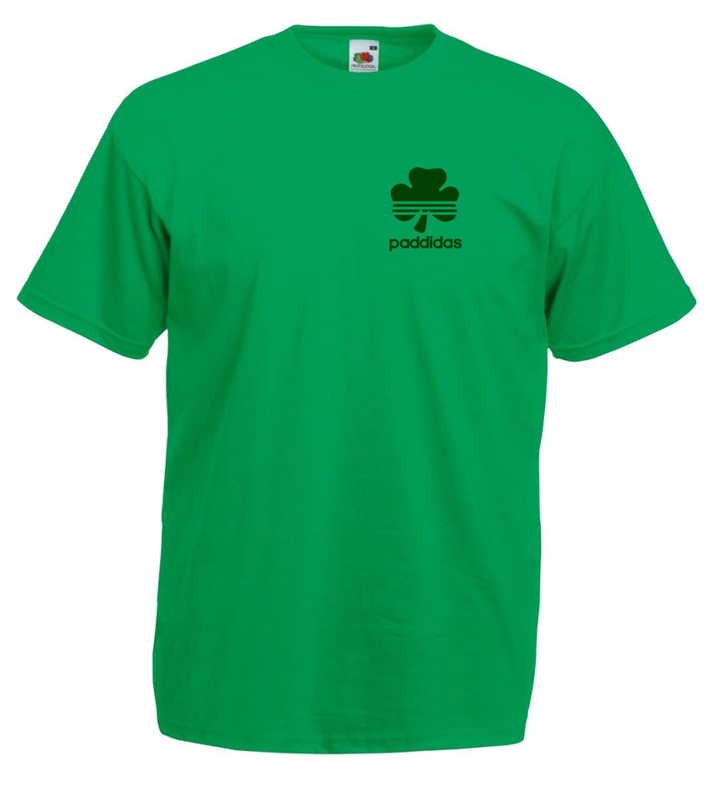 May include: A green t-shirt with a black shamrock and the text "paddidas" printed on the front.