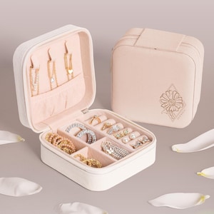 May include: A white jewelry box with a floral design and the word "JESSICA" engraved on the lid. The box is open and filled with various jewelry, including necklaces, earrings, and rings.