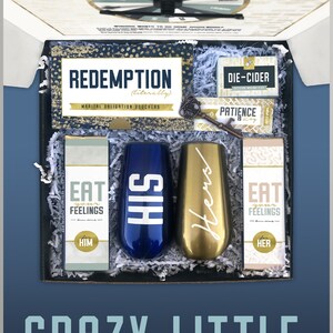May include: A gift box set for couples with the text "Crazy Little Thing Called Love - A Marriage Survival Kit" on the front. The box contains two champagne flutes, one blue and one gold, with the words "His" and "Hers" on them. The box also contains two small boxes with the text "Eat Your Feelings" and a key with a tag that says "Patience is Key".